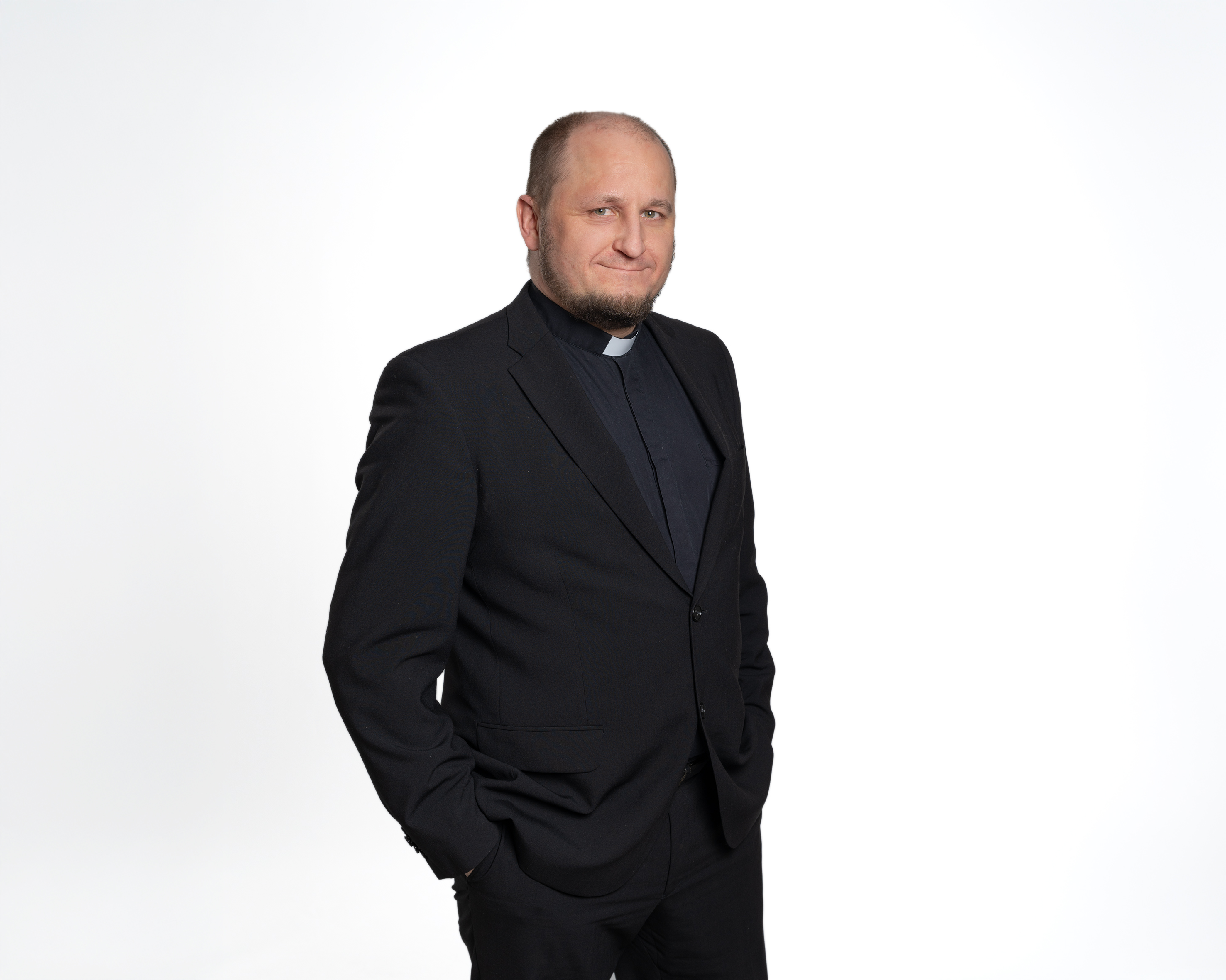 Kirkkoherra Olli Viitaniemi tummassa puvussa.
