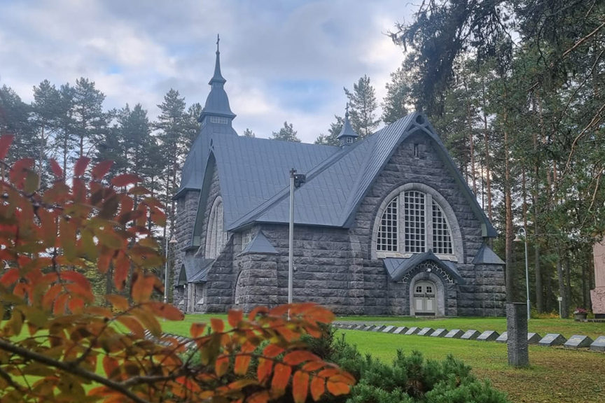 Varpaisjärven Pyhän Mikaelin kirkko, etualalla syksyn väreissä oleva pihlajan oksa.
