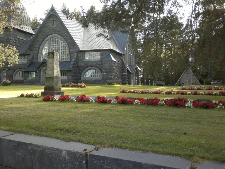 Varpaisjärven sankarihaudat, taustalla Varpaisjärven Pyhän Mikaelin kirkko.