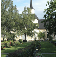 Hautakiviä Iisalmen vanhalla hautausmaalla. Taustalla Kustaa Aadolfin kirkko.